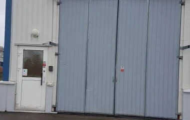 Interiör av lokal på Filaregatan 14. Exteriörbild av fordonsport med vanlig dörr intill.