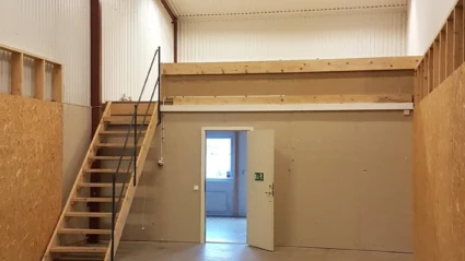 Interiör av lokal på Filaregatan 14. Stor tom yta med trappa upp ovanför kontorsdelen längst bort i bild.
